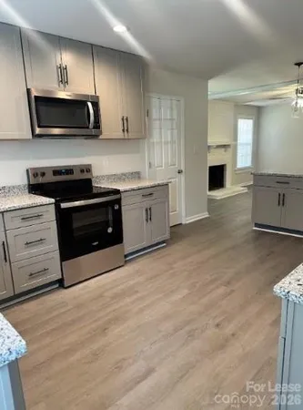 a large kitchen with stainless steel appliances granite countertop a stove a sink and a microwave