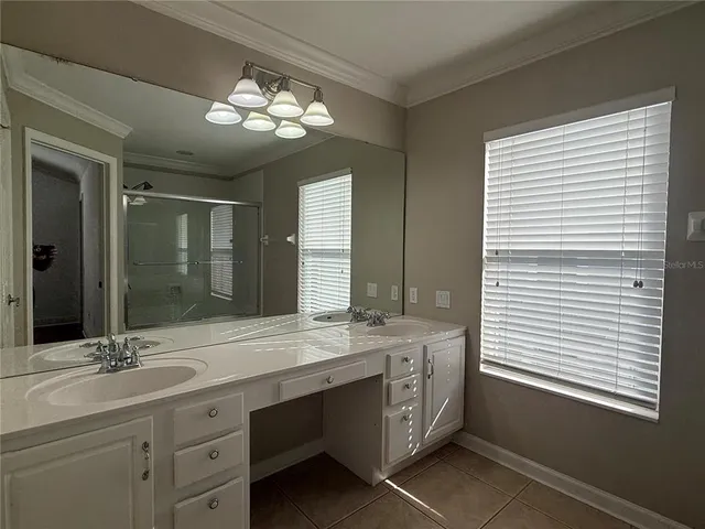 a spacious bathroom with a double vanity sink a large mirror and a window