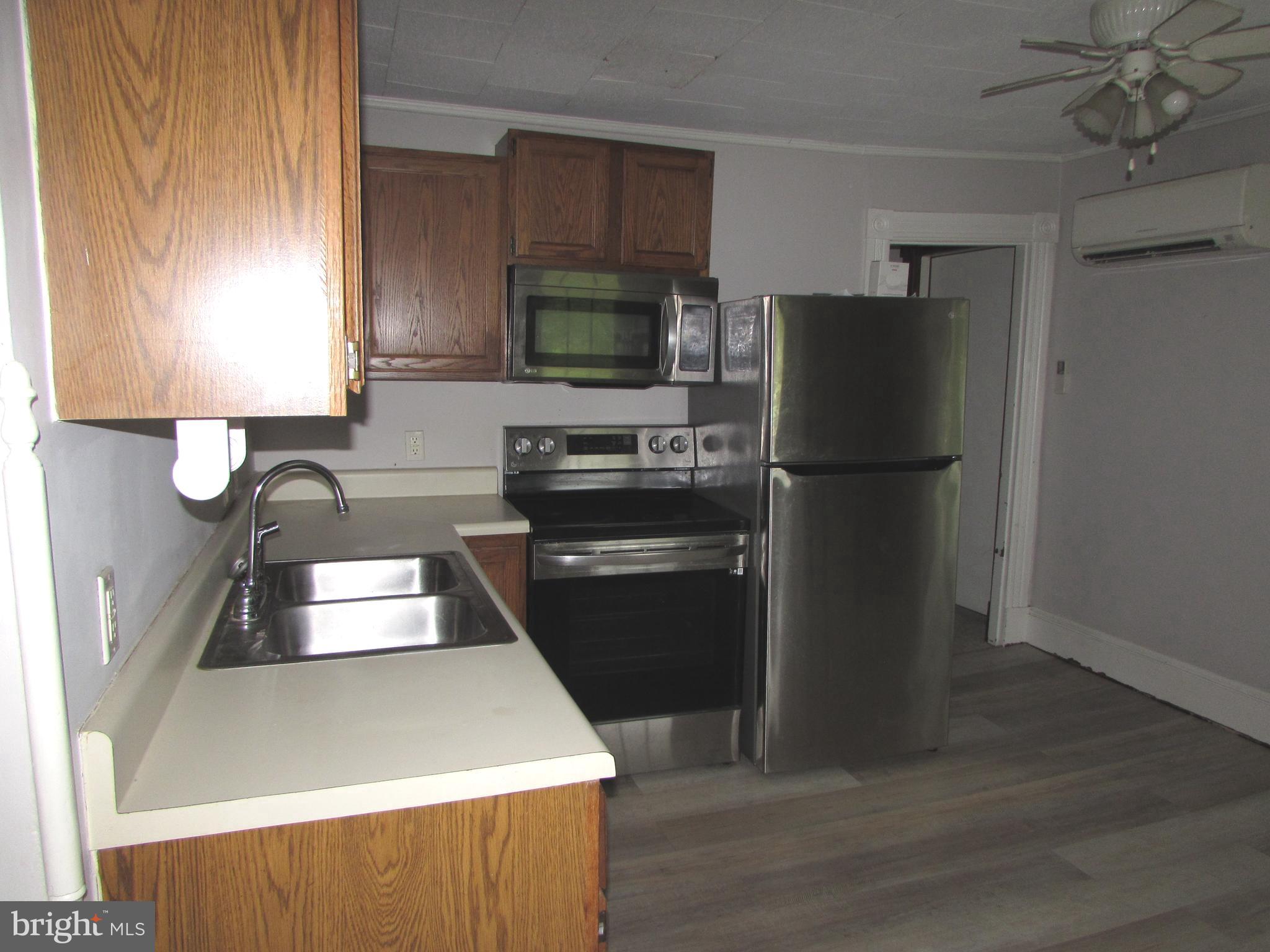 207 Gay Street Denton, MD 21629 - Photo 7 of 25 a kitchen with a refrigerator and a sink