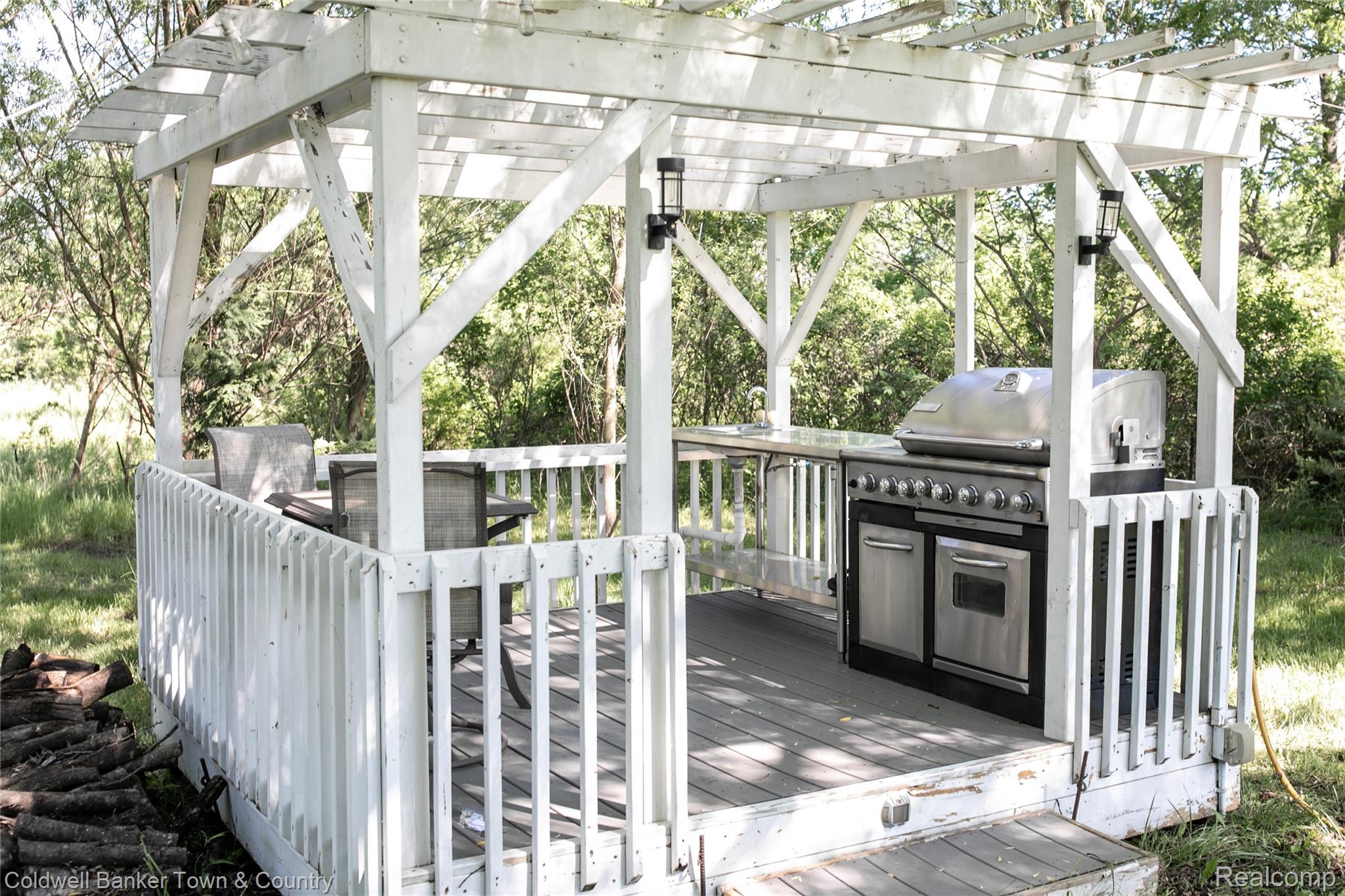 717 North Youngs Road Attica, MI 48412 - Photo 68 of 87 White pergola-covered outdoor kitchen featuring a built-in stainless steel grill, integrated countertop, and an outdoor sink