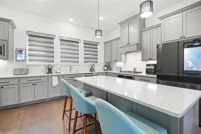 a large kitchen with granite countertop a sink chairs and cabinets