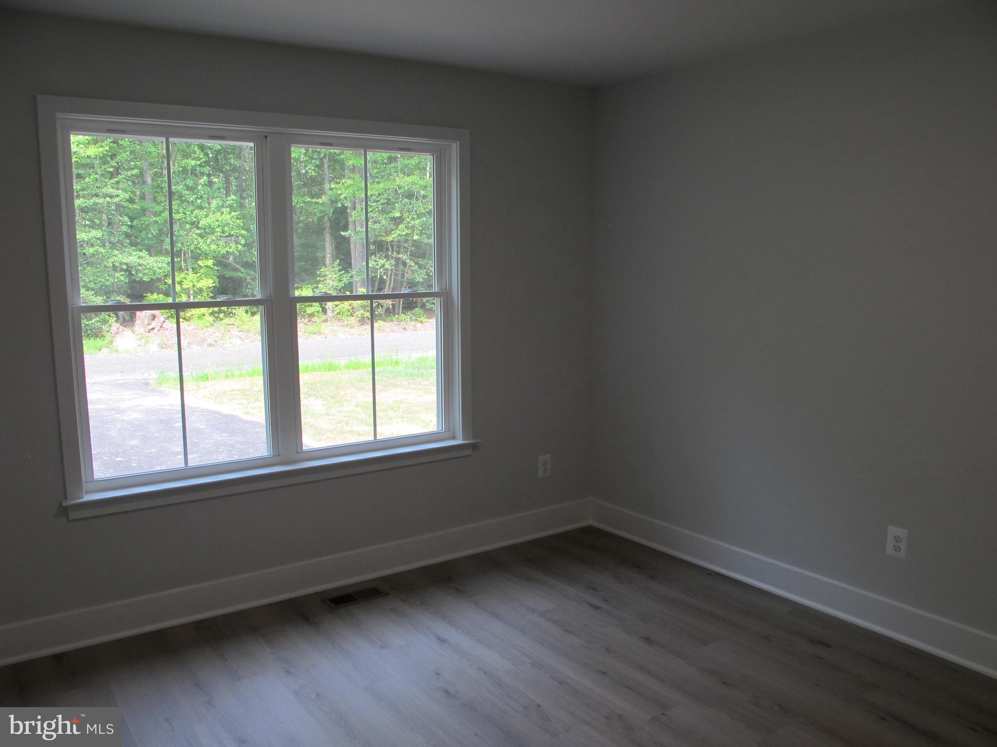 23 A 9th Street Colonial Beach, VA 22443 - Photo 13 of 56 an empty room with wooden floor and windows