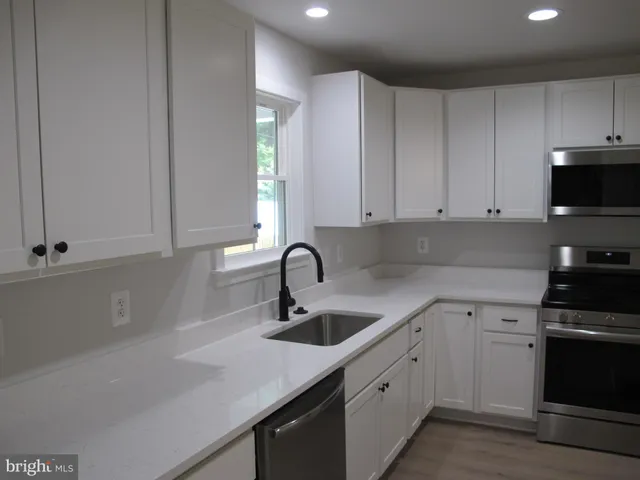 a kitchen with stainless steel appliances granite countertop a stove a microwave and a refrigerator