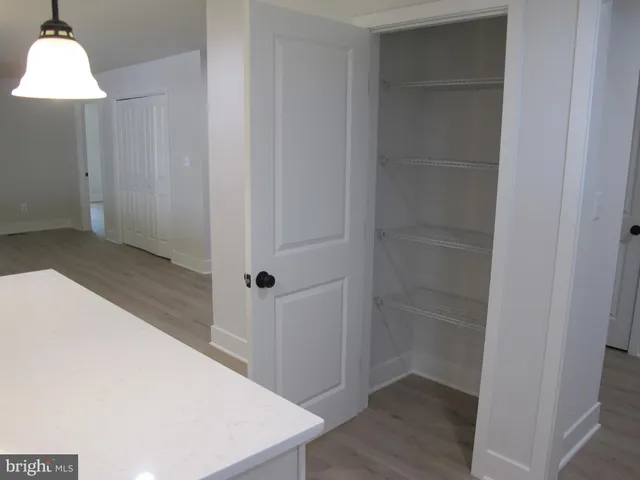 wooden floor in an empty room with a kitchen