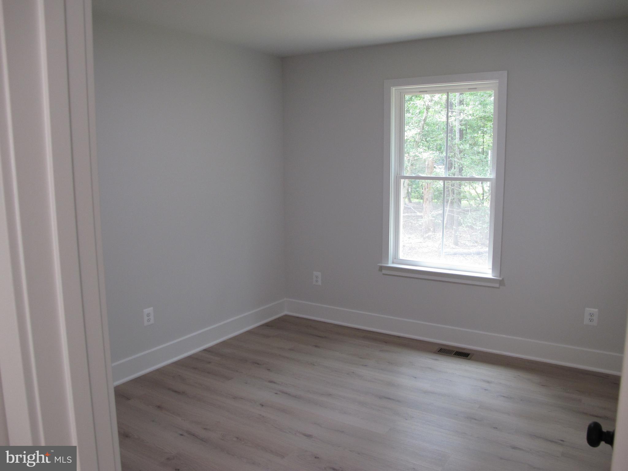23 A 9th Street Colonial Beach, VA 22443 - Photo 37 of 56 an empty room with wooden floor and windows