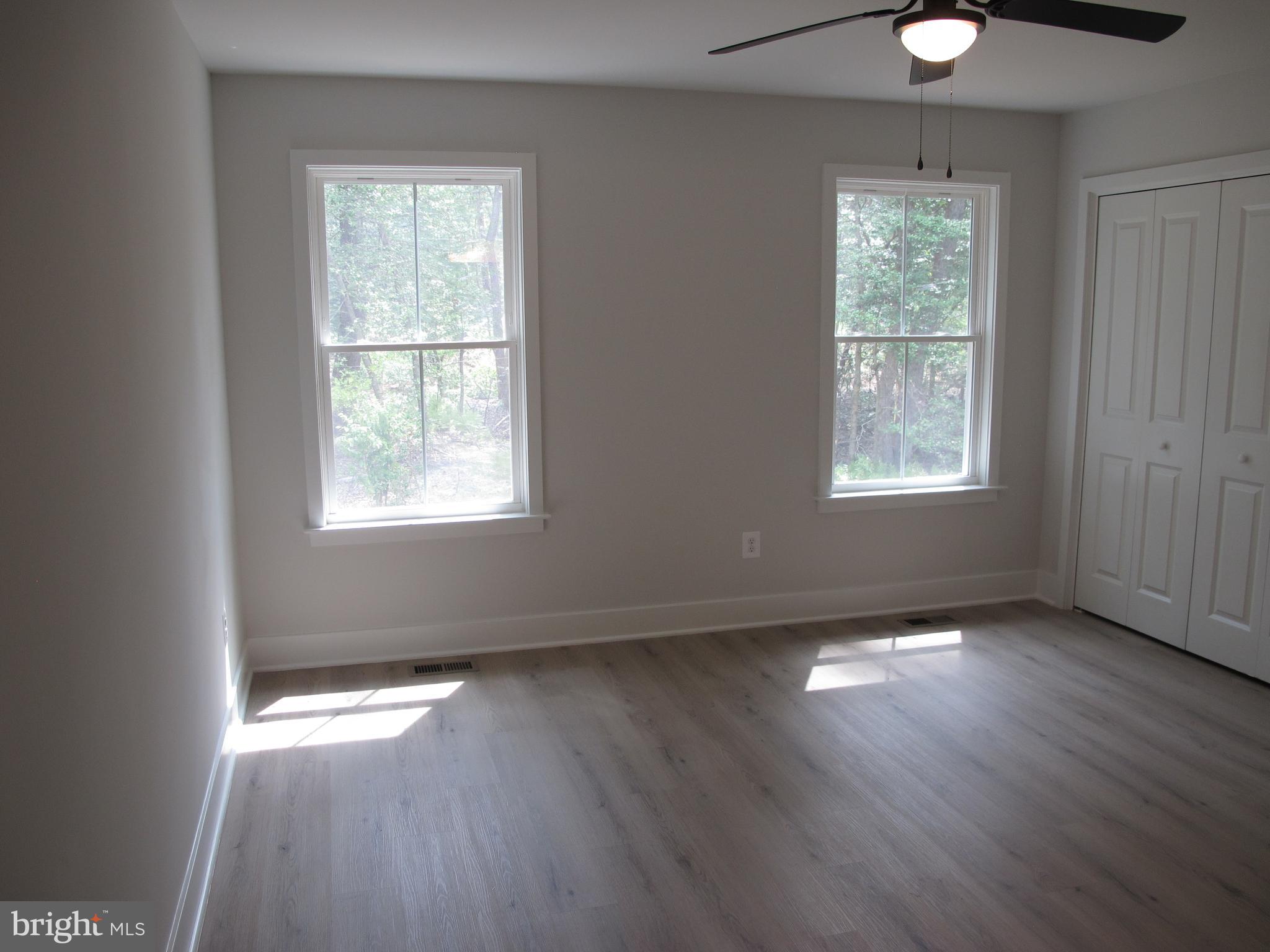 23 A 9th Street Colonial Beach, VA 22443 - Photo 41 of 56 an empty room with wooden floor and windows