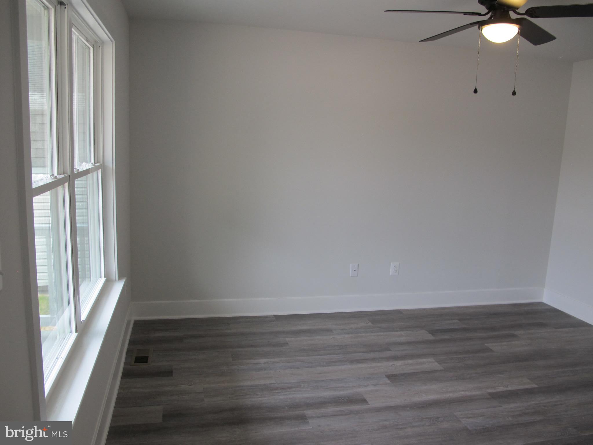 23 A 9th Street Colonial Beach, VA 22443 - Photo 9 of 56 a view of an empty room with wooden floor and windows