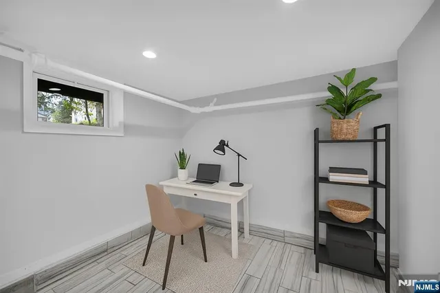a view of a workspace with furniture and wooden floor