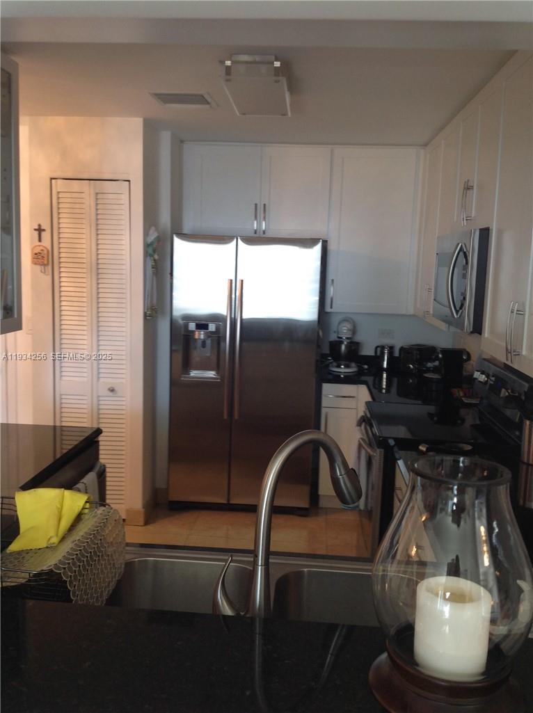 801 Brickell Key Boulevard, Unit 1004 Miami, FL 33131 - Photo 10 of 24 a kitchen with a refrigerator and a sink