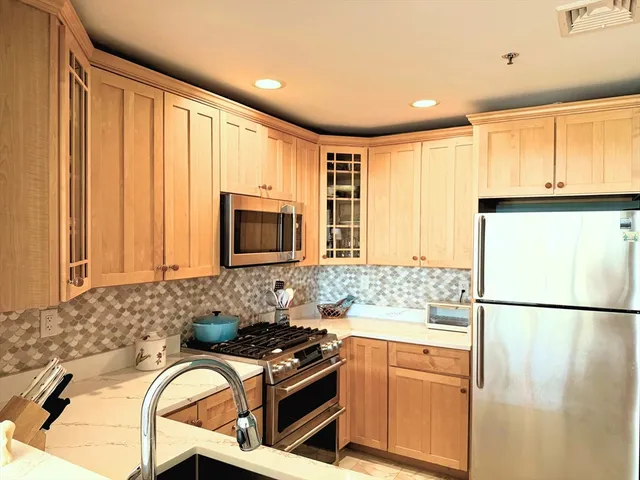 a kitchen with stainless steel appliances granite countertop a refrigerator sink and stove