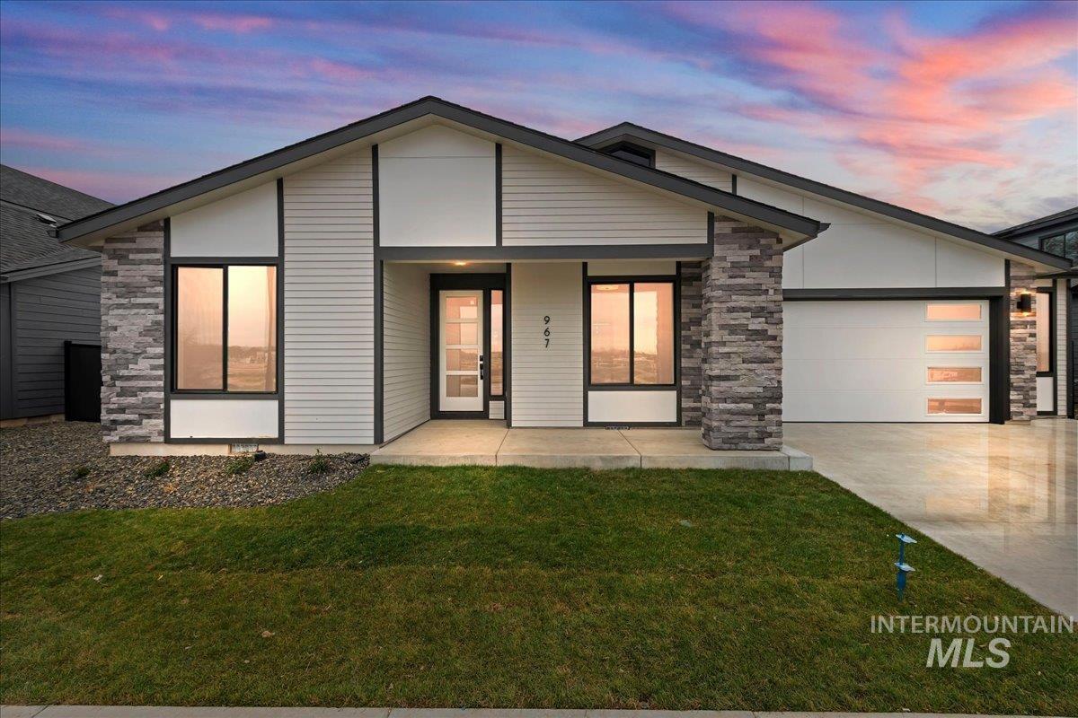 967 West Malbar Street Meridian, ID 83646 - Photo 1 of 33 View of front of property featuring stone siding, covered porch, a garage, and a lawn