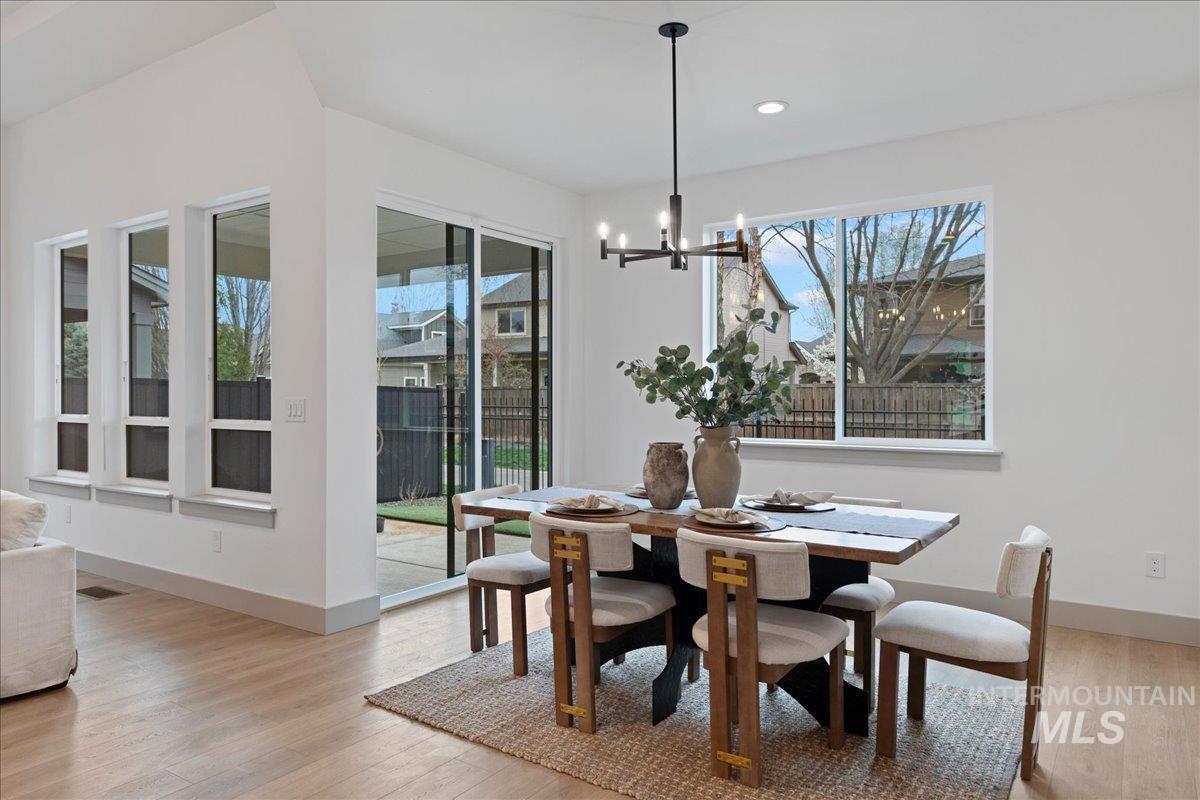 967 West Malbar Street Meridian, ID 83646 - Photo 12 of 33 Dining room with light wood-type flooring, suspended lighting, and plenty of natural light