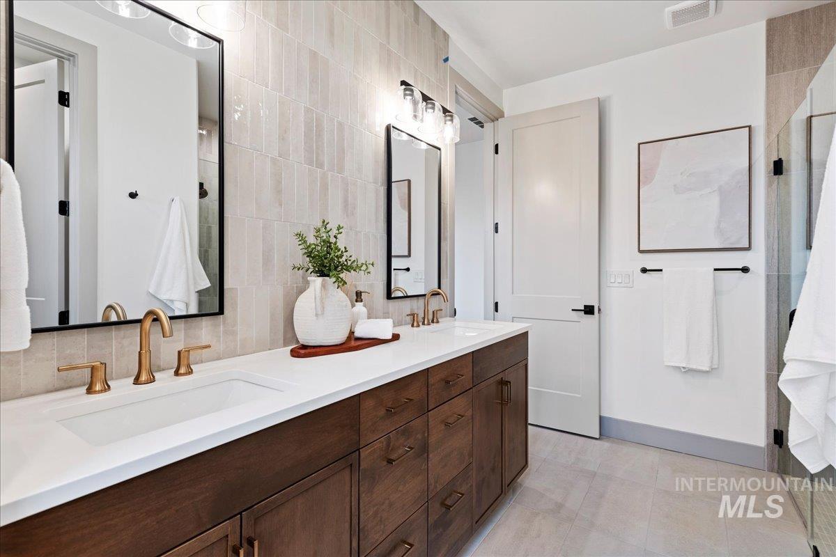 967 West Malbar Street Meridian, ID 83646 - Photo 17 of 33 Bathroom featuring double vanity, a stall shower, and decorative backsplash