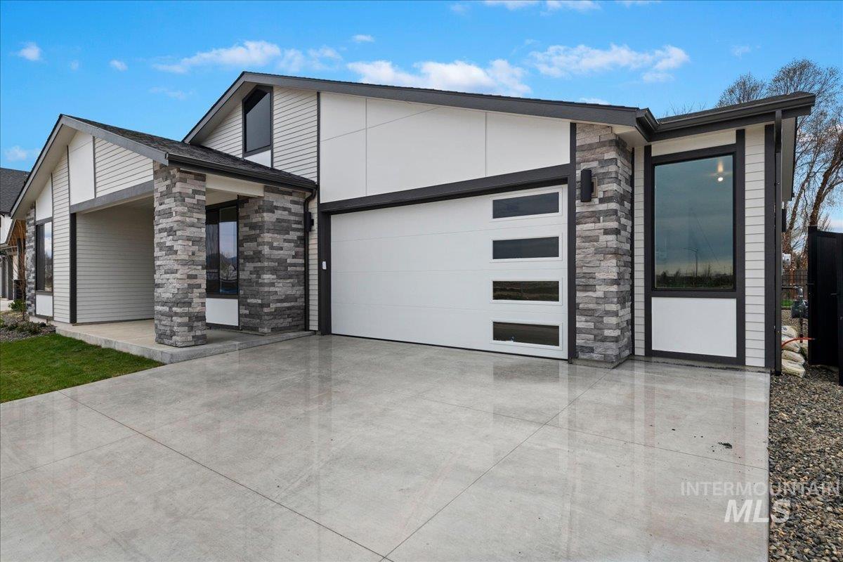 967 West Malbar Street Meridian, ID 83646 - Photo 2 of 33 Contemporary home with stone siding, concrete driveway, and an attached garage