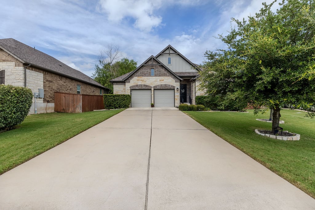 1509 Highland Ridge Road Georgetown, TX 78628 - Photo 1 of 1 A welcoming facade showcases brick and stone detailing, an inviting two-car garage, and a manicured front lawn.