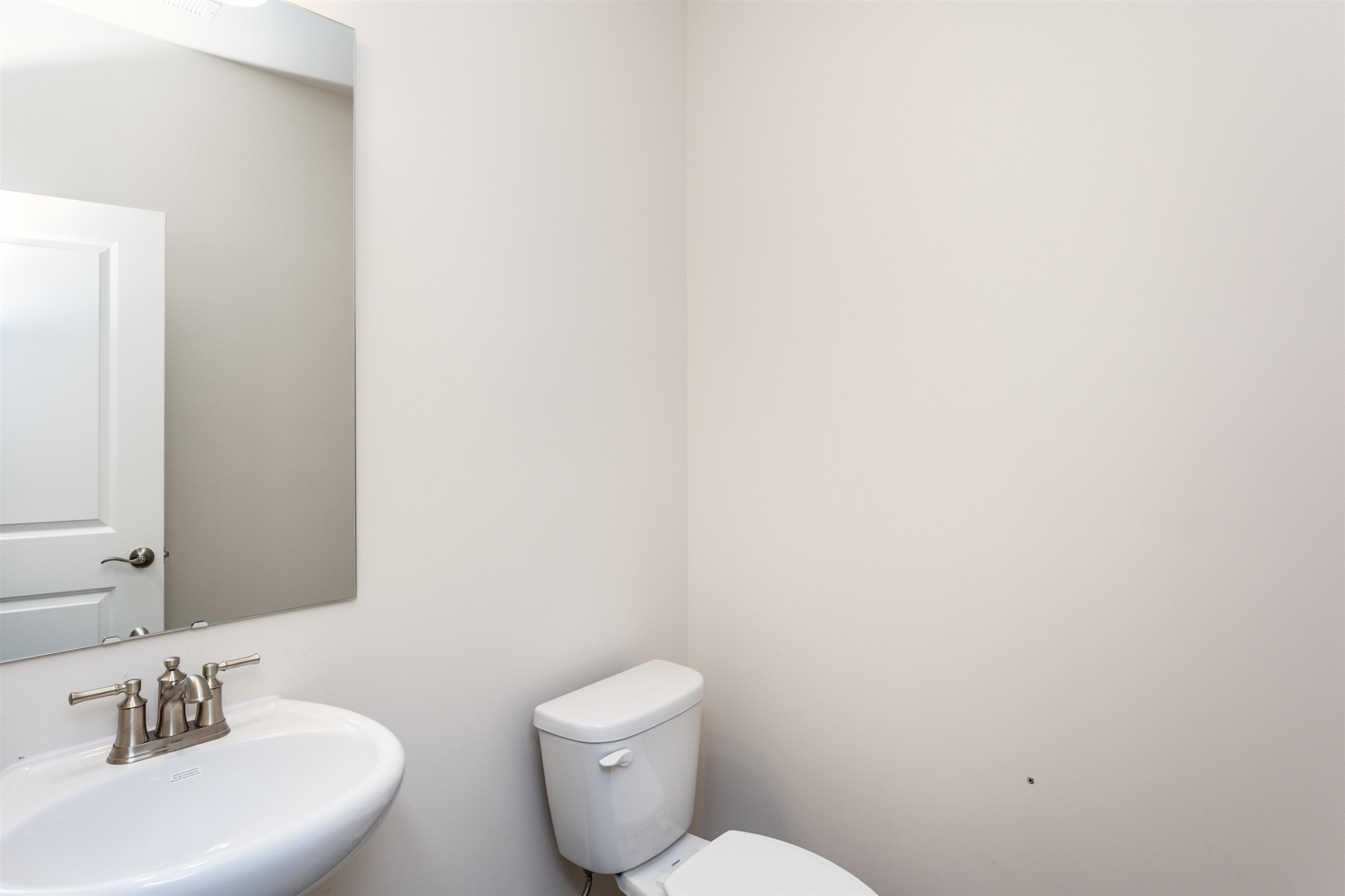 5602 Preveza Place Raleigh, NC 27603 - Photo 11 of 21 a bathroom with a toilet a sink and mirror