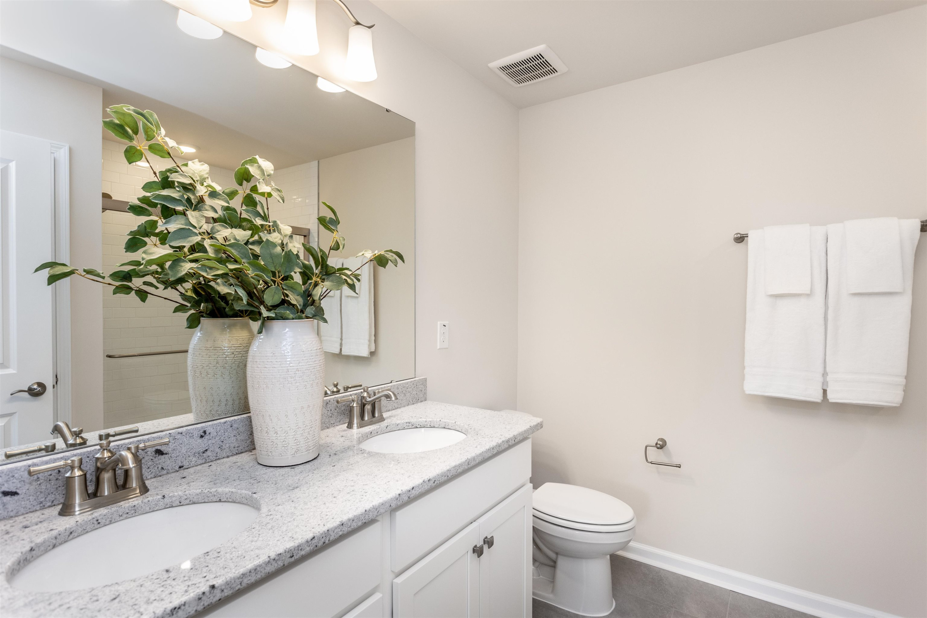 5602 Preveza Place Raleigh, NC 27603 - Photo 14 of 21 a bathroom with a granite countertop toilet a sink and a mirror