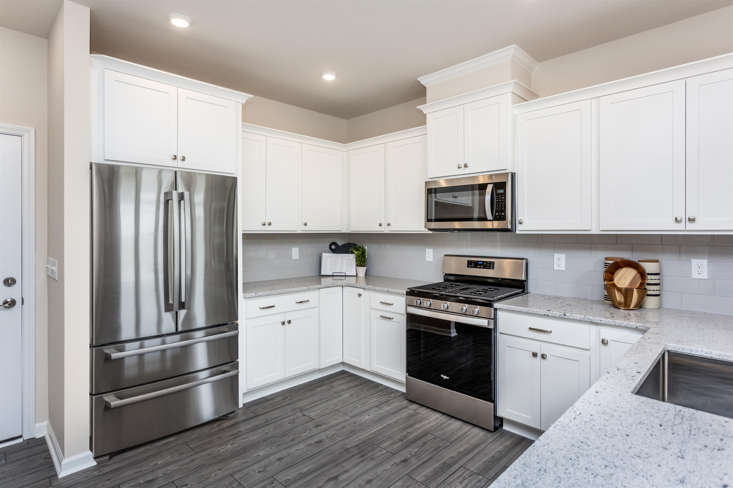 5602 Preveza Place Raleigh, NC 27603 - Photo 7 of 21 a kitchen with stainless steel appliances and white cabinets