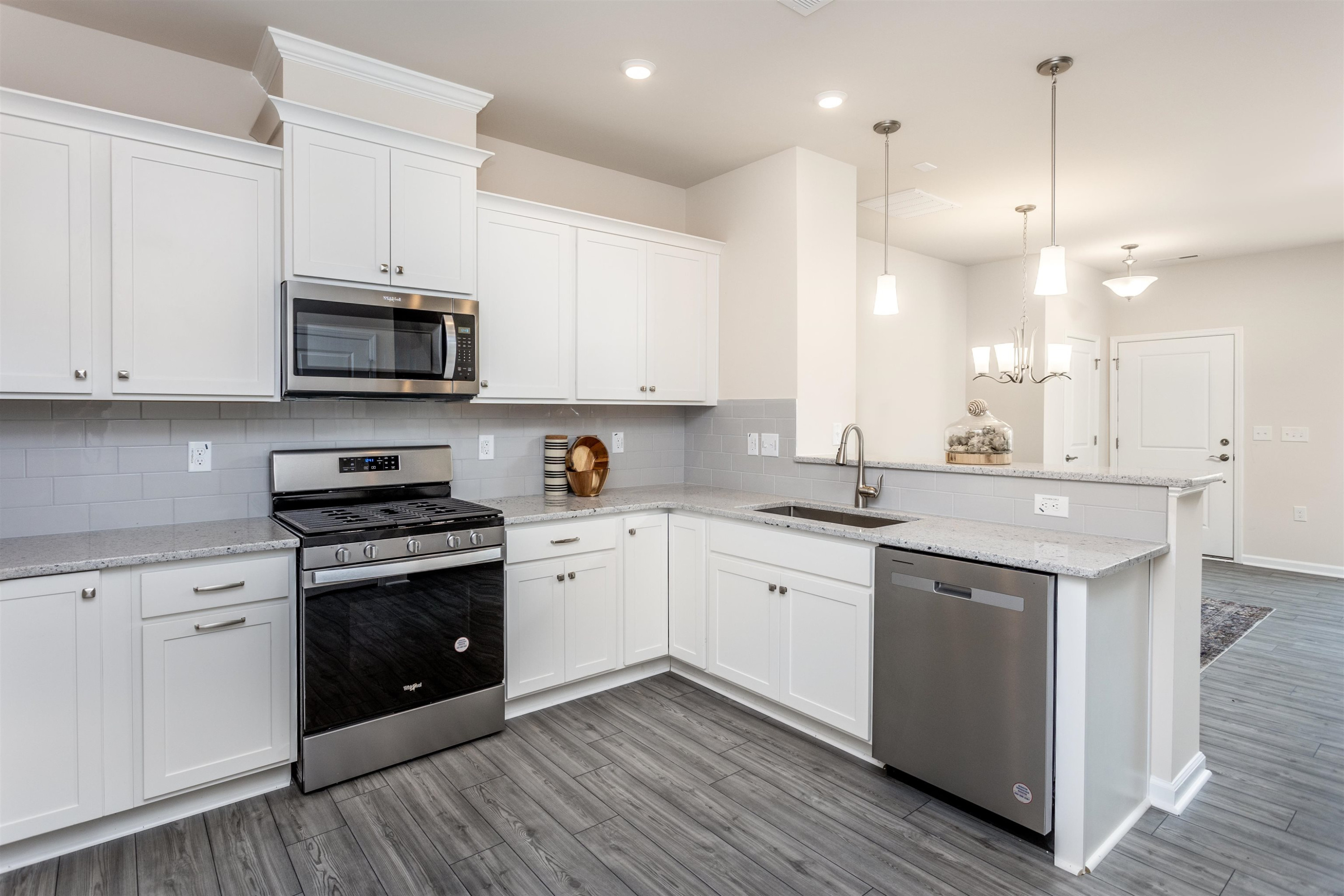 5602 Preveza Place Raleigh, NC 27603 - Photo 8 of 21 a kitchen with stainless steel appliances granite countertop a sink a stove a refrigerator and white cabinets