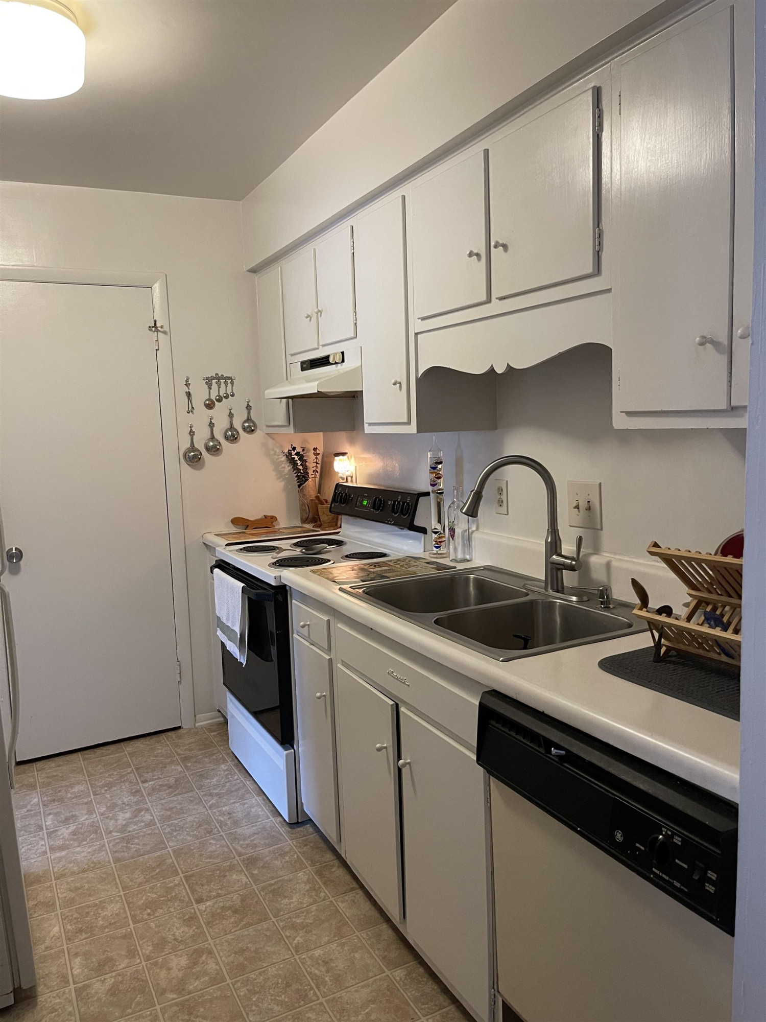 1010 Sandlin Place, Unit H Raleigh, NC 27606 - Photo 6 of 15 a kitchen with sink a stove and cabinets