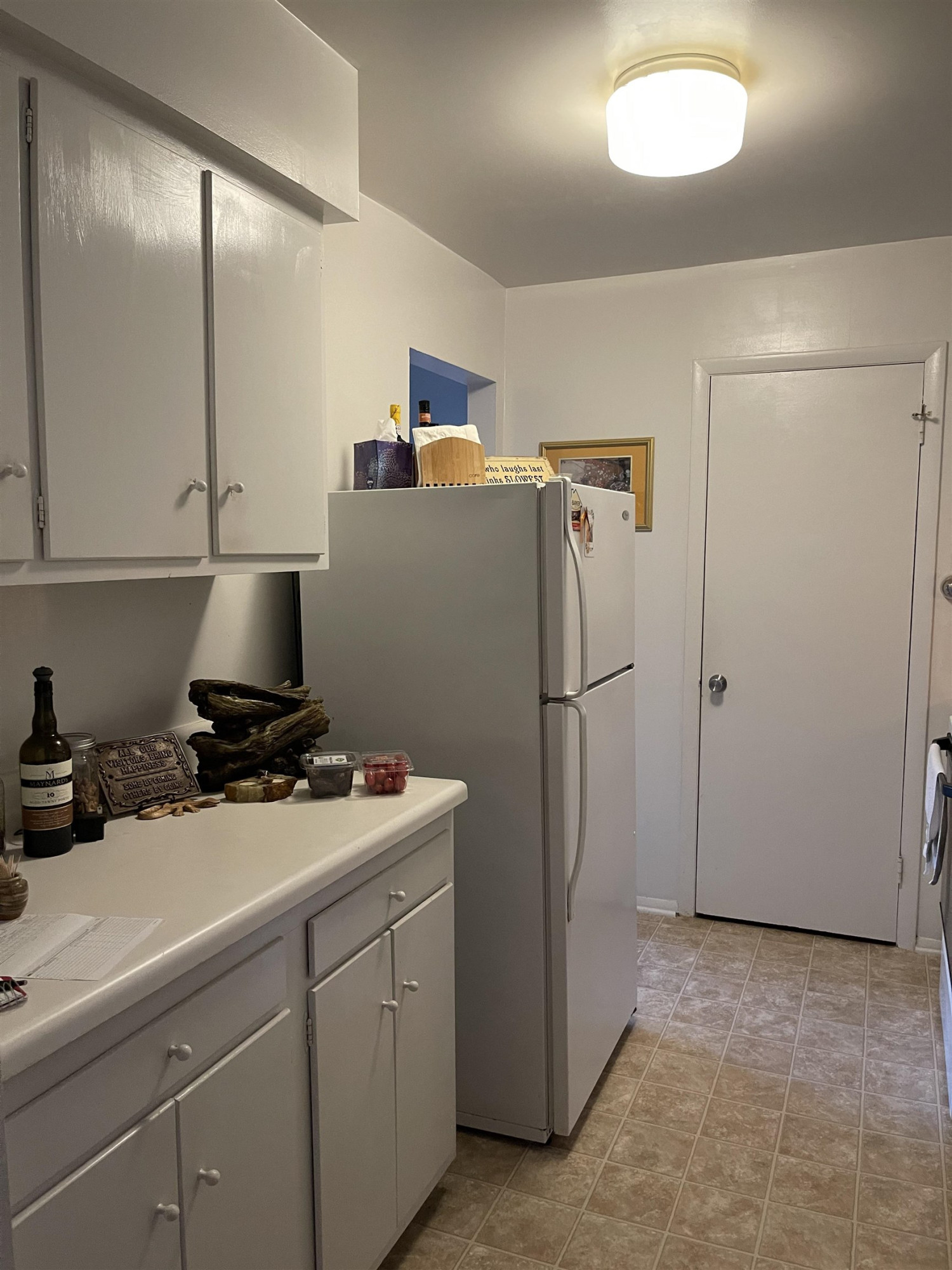 1010 Sandlin Place, Unit H Raleigh, NC 27606 - Photo 7 of 15 a kitchen with refrigerator a stove a microwave and cabinets