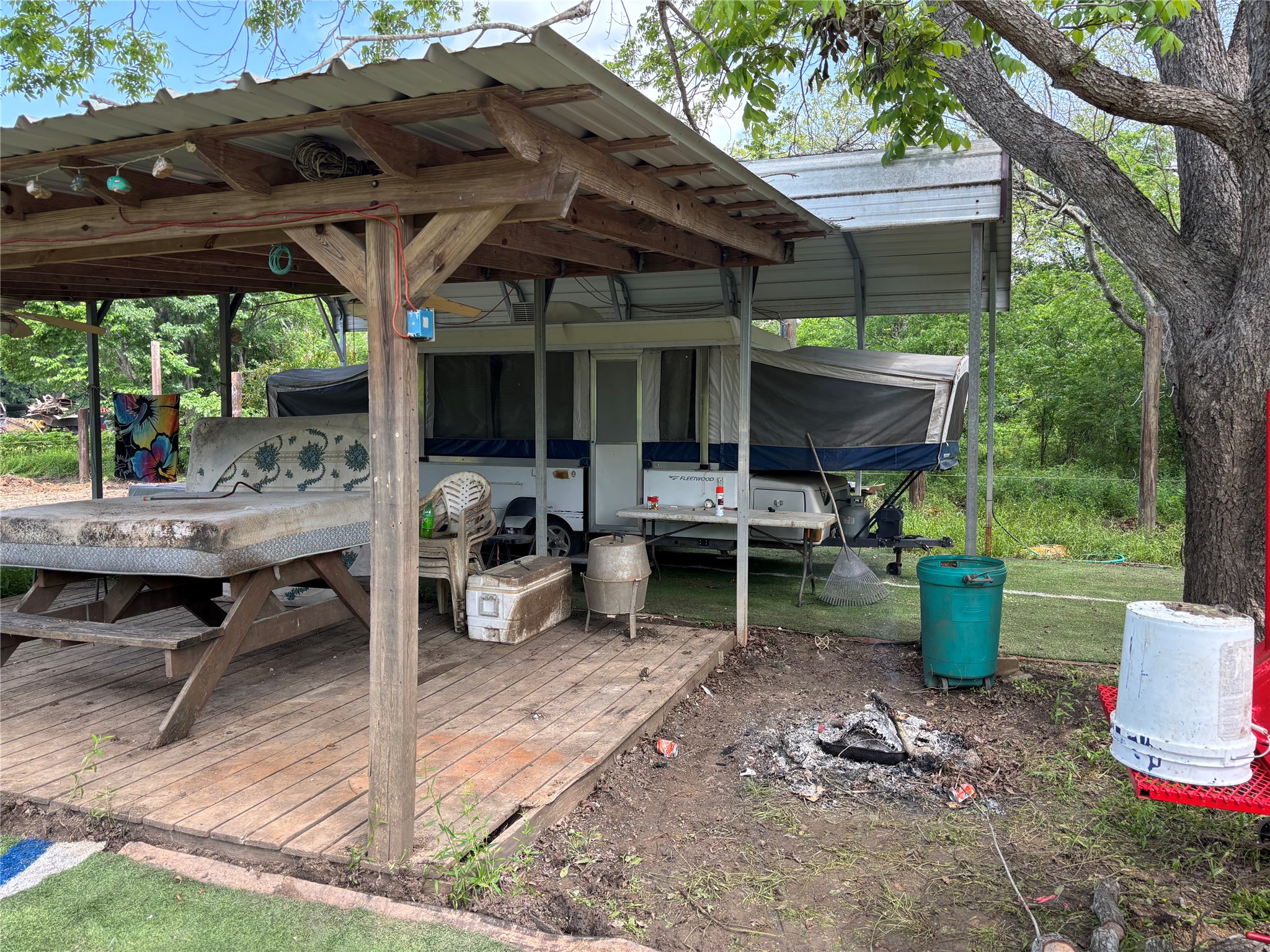161 Powell Road Trinity, TX 75862 - Photo 2 of 4 a view of a patio with table and chairs potted plants and a large tree