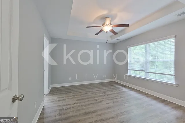 an empty room with windows and fan