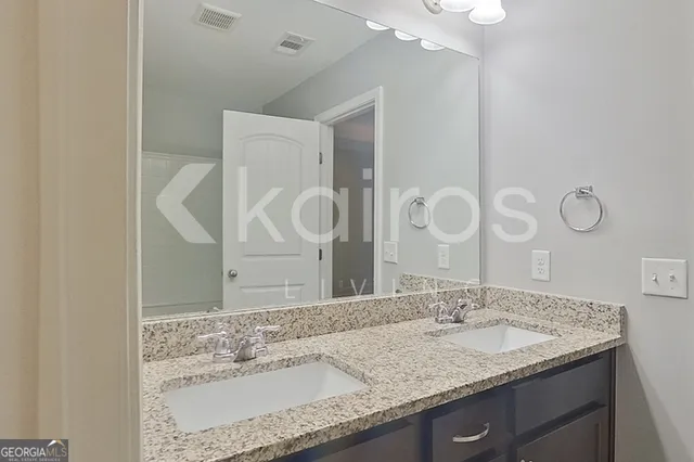 a bathroom with a granite countertop sink a mirror and shower