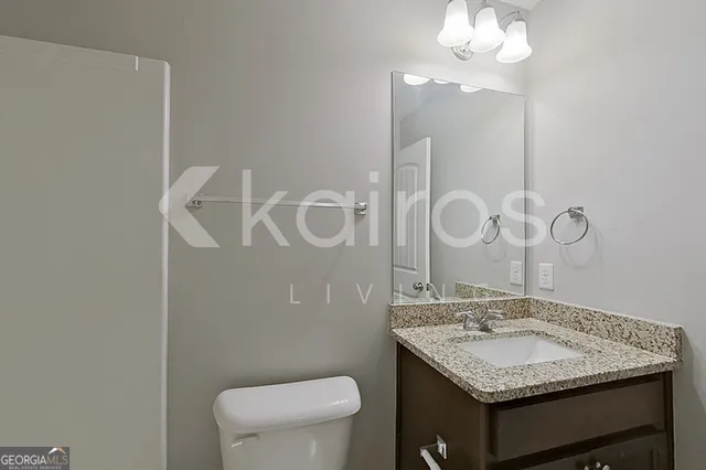 a bathroom with a sink a toilet and a mirror