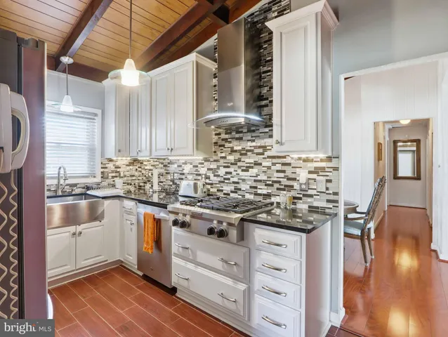 a kitchen with granite countertop white cabinets and white appliances