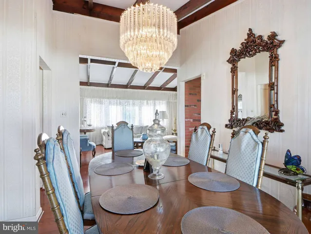 a view of a dining room with furniture a chandelier and wooden floor