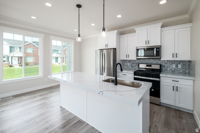 8797 Green Way, Unit 3 Sandy, UT 84094 - Photo 3 of 12 Kitchen featuring appliances with stainless steel finishes, ornamental molding, light stone countertops, decorative backsplash, and white cabinets
