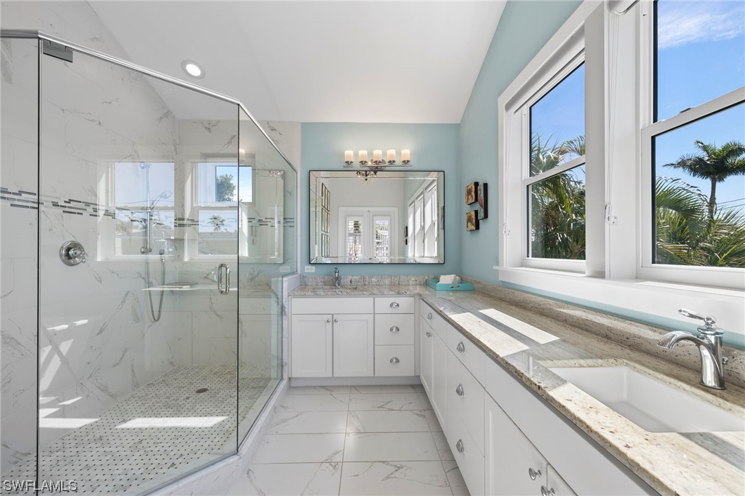 11517 Wightman Lane Captiva, FL 33924 - Photo 14 of 48 a large bathroom with a granite countertop tub a sink and a large mirror