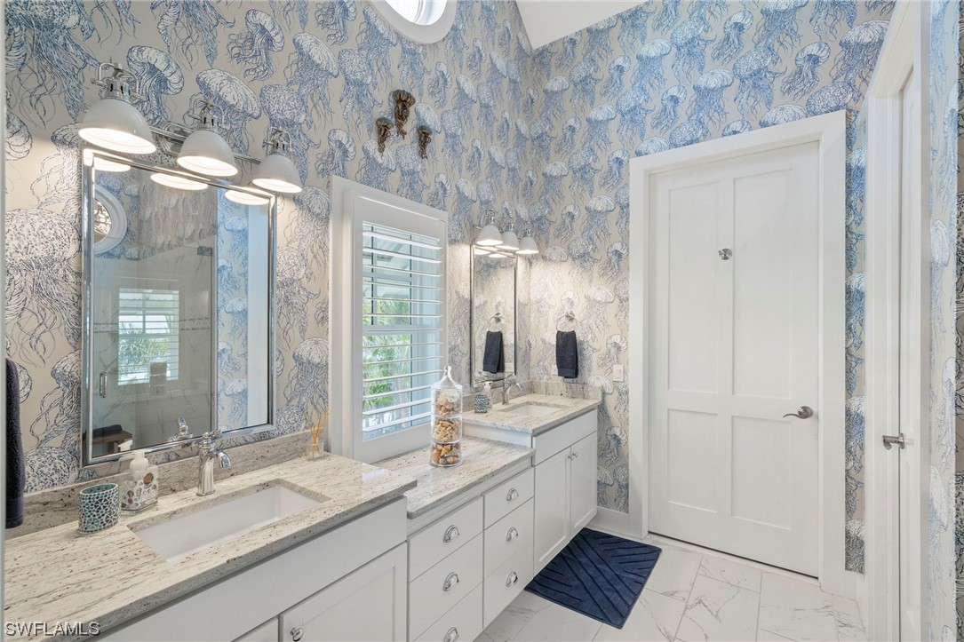 11517 Wightman Lane Captiva, FL 33924 - Photo 18 of 48 a spacious bathroom with double vanity and a mirror