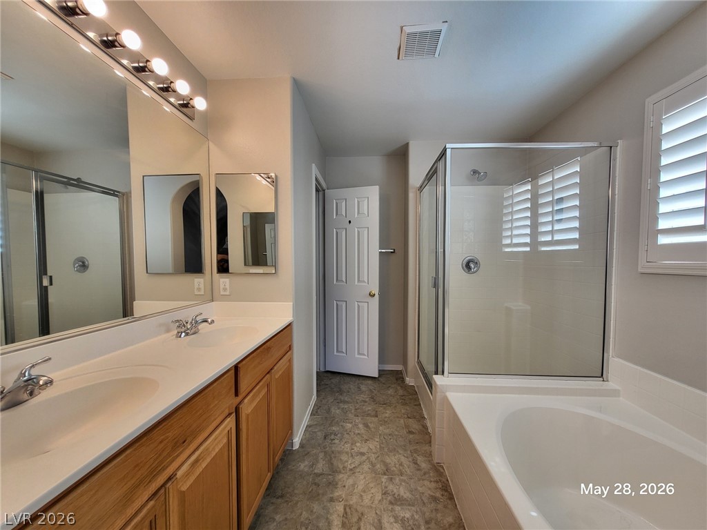 9843 West Overlook Ridge Avenue Las Vegas, NV 89148 - Photo 14 of 19 Dual vanity sinks provide ample space in this well-appointed bath, featuring a separate shower and soaking tub.