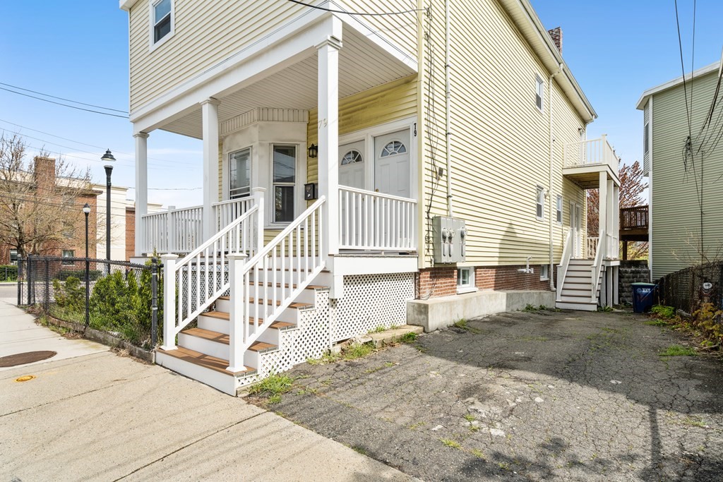 79 Derby Street, Unit 2 Somerville, MA 02145 - Photo 17 of 18 a view of a house with a floor to ceiling window and wooden fence