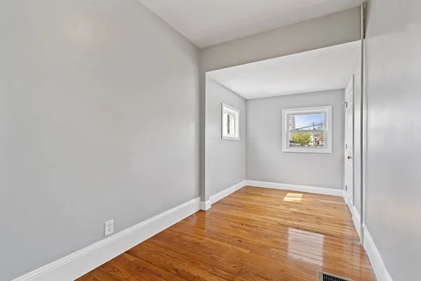 a view of empty room with wooden floor