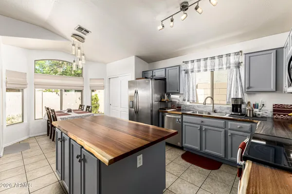 a kitchen with granite countertop stainless steel appliances a sink stove and cabinets