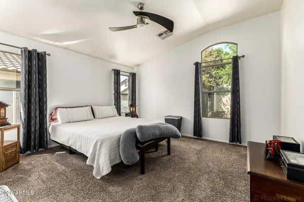 a spacious bedroom with a bed and a chandelier