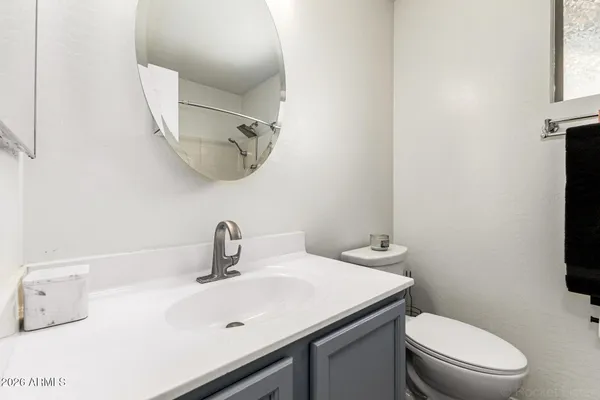 a bathroom with a sink a toilet and mirror