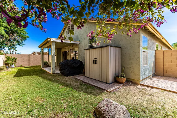 a view of a house with a small yard and sitting area