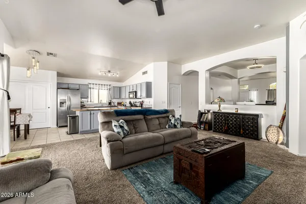 a living room with furniture and a view of kitchen appliances