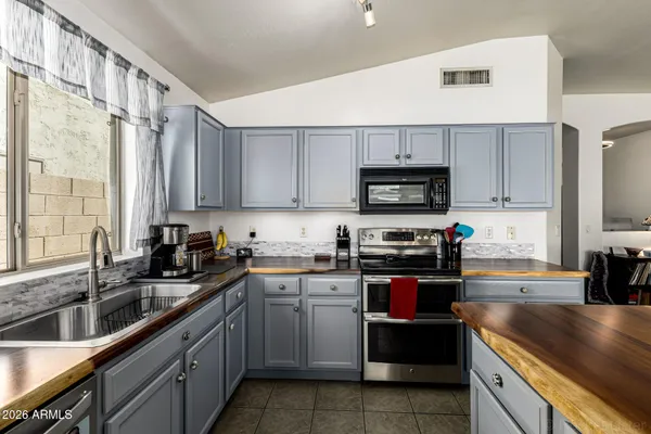 a kitchen with stainless steel appliances a sink a stove and a microwave
