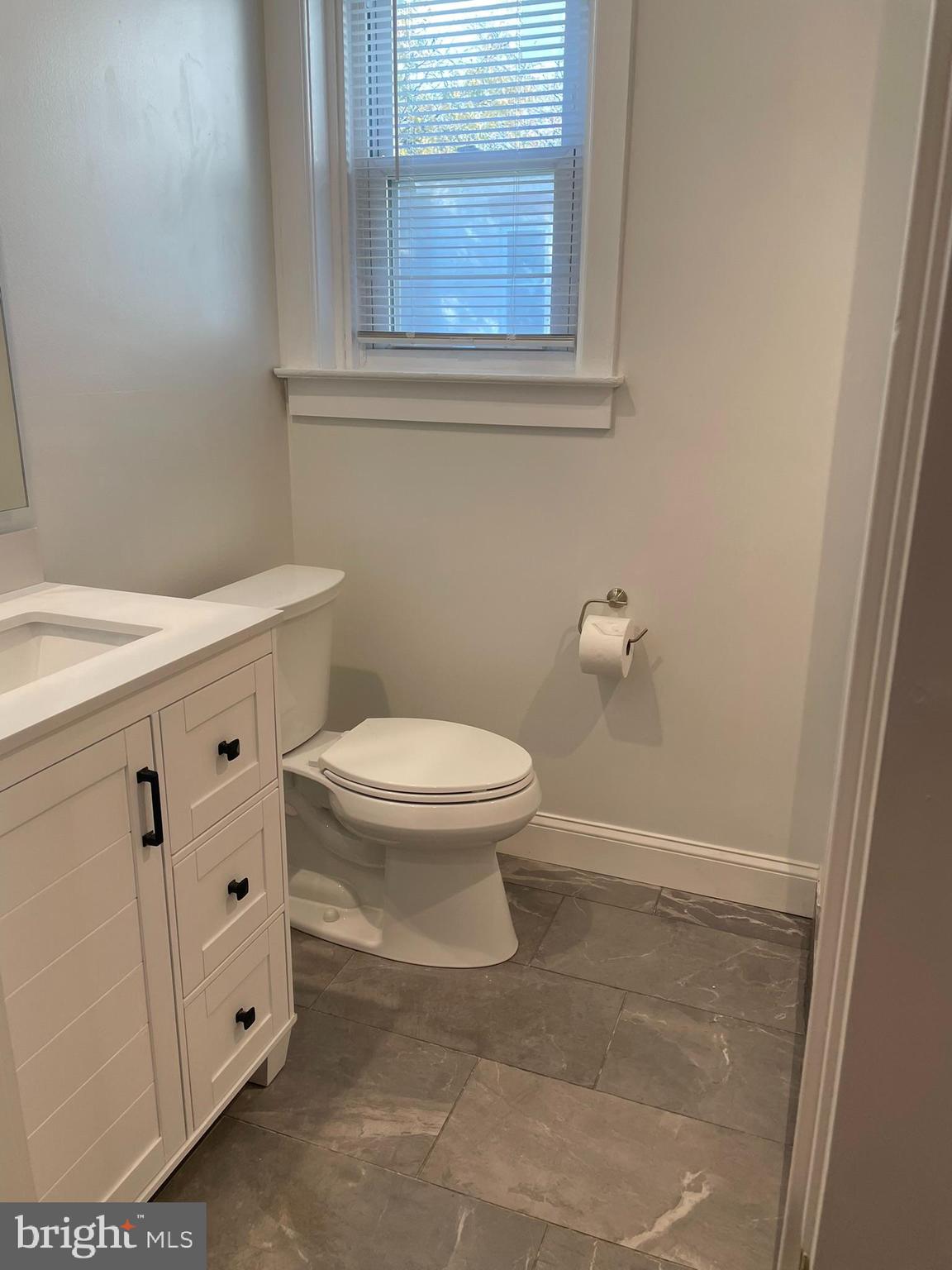 346 Parker Street Chester, PA 19013 - Photo 26 of 32 a bathroom with a toilet a sink a vanity and a window
