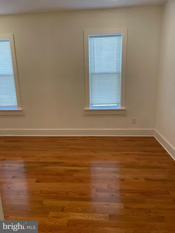 a view of a small space with wooden floor and a window