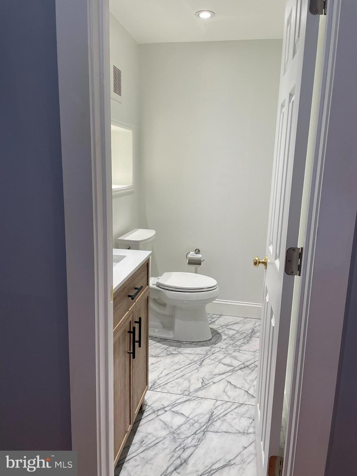 346 Parker Street Chester, PA 19013 - Photo 7 of 32 a bathroom with a granite countertop toilet a sink a mirror and a shower