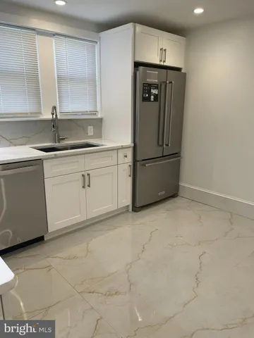 a kitchen with stainless steel appliances granite countertop a refrigerator and a sink