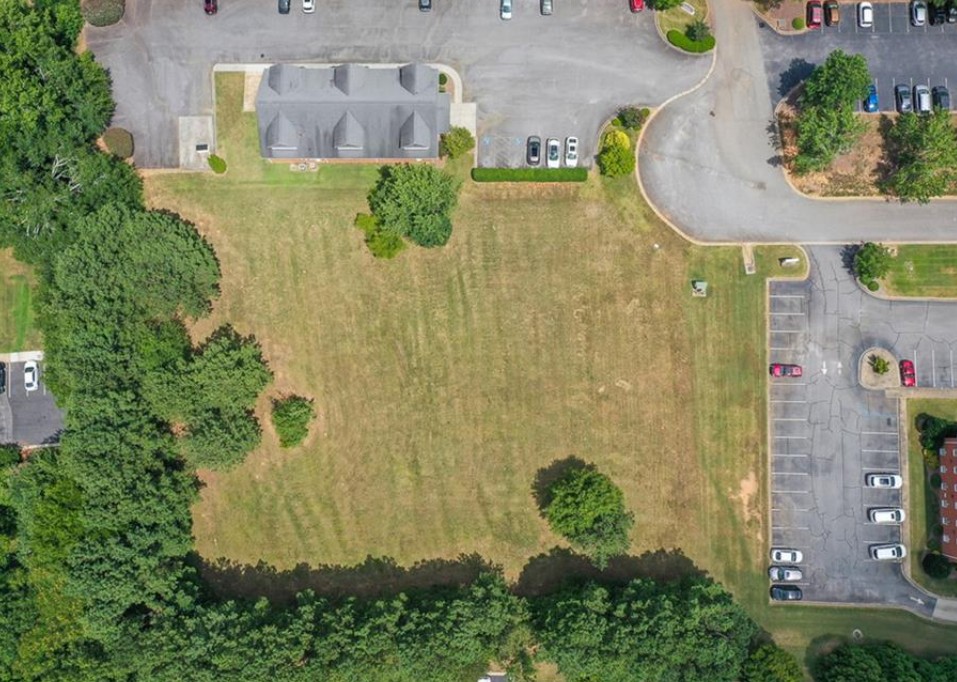 120 Perpetual Square Drive Anderson, SC 29621 - Photo 8 of 14 An aerial view showcases a verdant lot bordered by parking, roads, and a commercial structure.