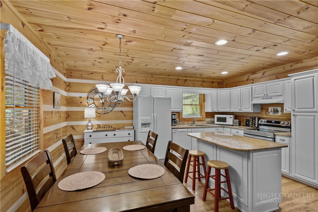 339 Welcome Way Boone, NC 28607 - Photo 6 of 20 a kitchen with stainless steel appliances kitchen island granite countertop a table chairs stove and kitchen view