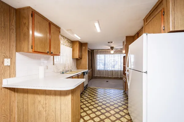a kitchen with a refrigerator a sink and cabinets